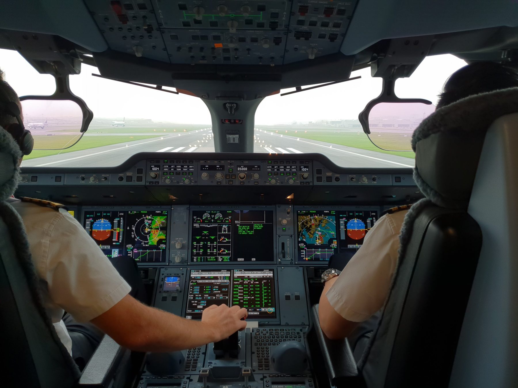 Two pilots on a jet flight deck, lined up on the runway before take-off